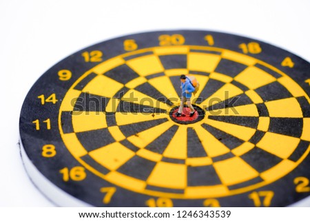 Miniature people : 
Traveler walking on dart board,picture use for travel and holiday concept .