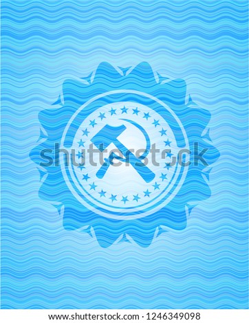 sickle and hammer icon inside light blue water wave emblem.