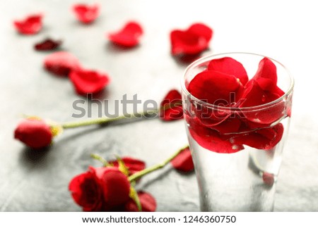 Natural rose water drink with red rose petals,