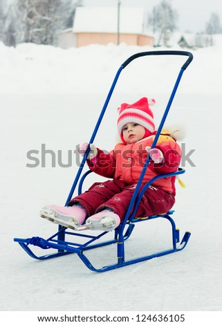 Happy baby in red clothes in winter outdoors