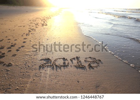 2019 written in sand beach on the sunset.