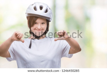 Young adult cyclist woman with down syndrome wearing safety helmet over isolated background looking confident with smile on face, pointing oneself with fingers proud and happy.