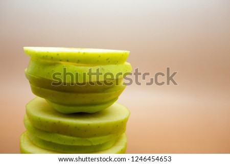 Slicing green apples on a light background