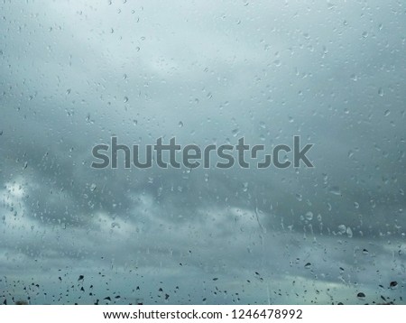 The  rainy sky in cloudy day through a wet window for background texture and decoration design card