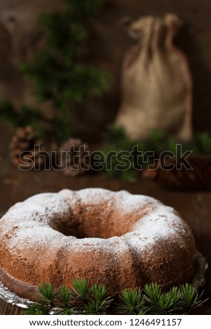 Christmas bundt cake with pine branches on wooden table
