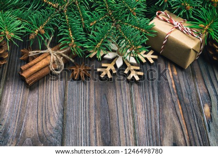 Christmas vintage, toned background with fir tree and gift box on wooden table. Top view with copy space for your design.