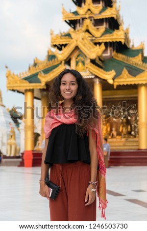 Vertical picture of young asian eyes woman at Shwedagon Pagoda, important religous site in Yangon, Myanmar