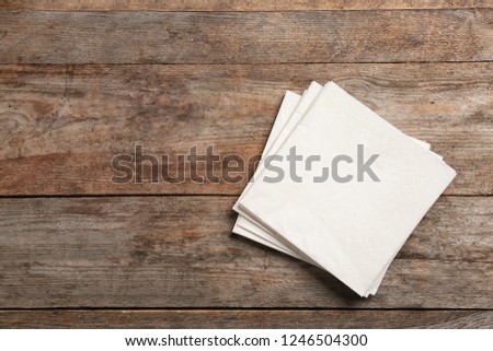 Clean napkins on wooden background, top view with space for text Royalty-Free Stock Photo #1246504300