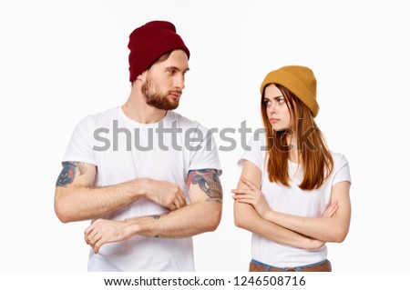 A man and a woman look at each other in different hats                 