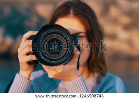 A woman is taking pictures on the background of nature      