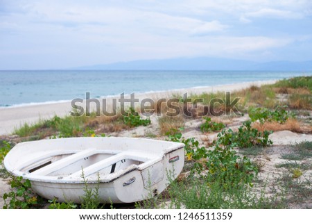 Old white boat on a beach. Italy. Calabria