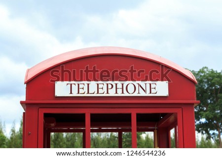 Old but classic red telephone booth displayed in a park is a tourist attraction and landmark for tourists to take pictures and selfies in the countryside in Thailand.