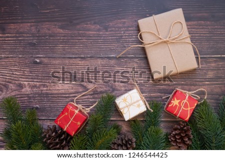 Christmas decoration, gift box and pine tree branches on wooden background, preparation for holiday concept, Happy New Year and Xmas Holidays. Top view and Copy Space for text