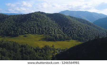 Green mountain valley, aerial landscape. Clip. Altai, Russia. Aerial Altai mountains landscape. Mountain range behind wooded plains. Altai mountains removed from the drone, aerial view