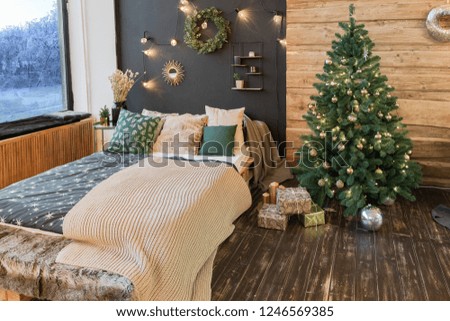 The interior of a country house is decorated with a Christmas tree in anticipation of the holiday. a large spacious light room is decorated with wood