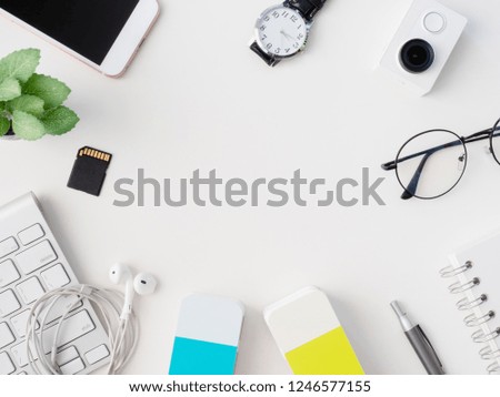 top view of Designer workspace with notebook, laptop, smartphone, Colour swatches book and keyboard on white background with copy space.
