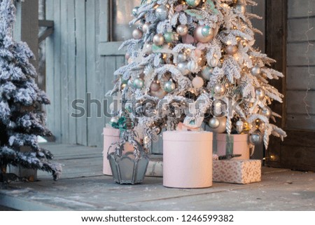 Home porche decorated with snow covered branches of a Christmas tree. Christmas decor, snowy mood, winter still life.