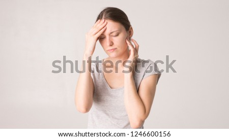 Young beautiful woman has headache, isolated