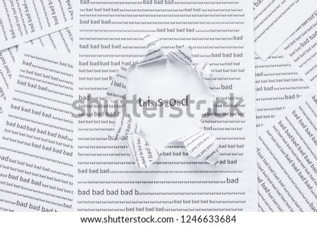 a torn hole in the sheet with the text "bad" and the words "it's good." sheets of paper with conceptual text "good" and " bad".