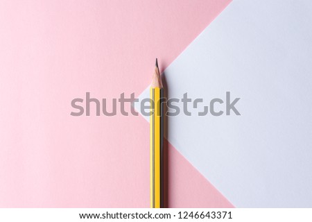 Yellow pencil on pastel textured paper background with copy space. Minimal concept.