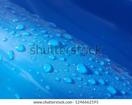Morning droplet on blue surface with a bit light bright on side