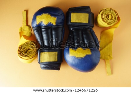 Wrestling gloves, yellow bandages, on an orange background