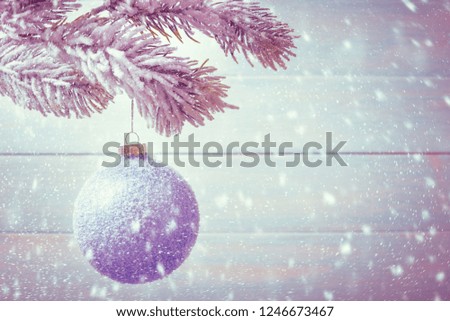 Christmas ball on Xmas tree over wooden background with copy space.