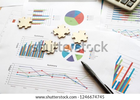 Sheet of graphs and jigsaws on a table with black pen shows report of business. Business concept Royalty-Free Stock Photo #1246674745