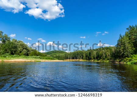 water stream in river of Amata in Latvia with sandstone cliffs, green foliage in summer morning