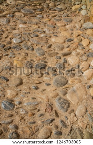 Old beige stone wall background texture close up
