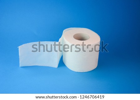 White toilet paper on a pastel blue background with empty space. Close up and copy space.
