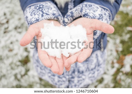 Snow on the palm in the hands of a little girl for design background
