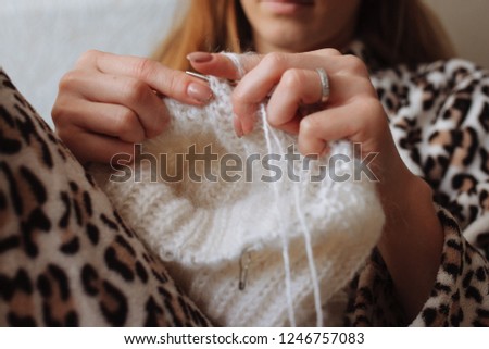 The woman hands knit natural woolen clothes. Knitting needles close-up. Horizontal photo. Freelance creative working. Handcraft concept