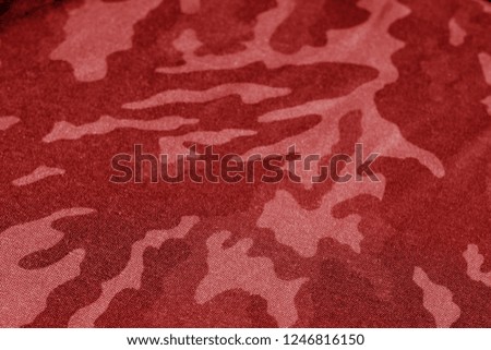 Old camouflage cloth with blur effect in red tone. Abstract background and texture for design abd ideas.