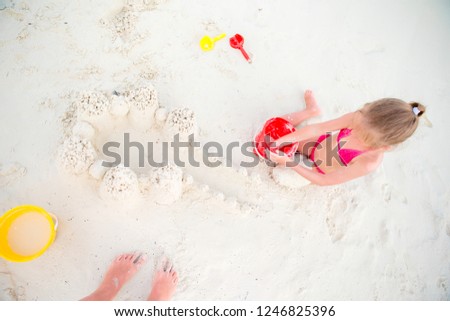 Adorable little girl playing with beach toys during summer maldivian vacation