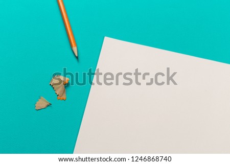 Pencils with sharpening shavings with white paper sheets on coloured backgroung, Office tool