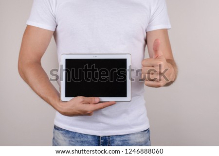 Cropped closeup studio photo portrait of satisfied good glad excited guy make give finger up holding small portable laptop computer isolated on grey background