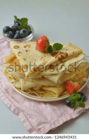 Homemade pancakes on a plate with blueberries and strawberries. Vertical image Food photo.