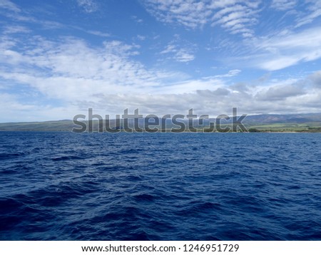Beautiful Pakala Village Coast with clouds covering the tops of mountains as seen from boat off shore of Kauai, Hawaii.