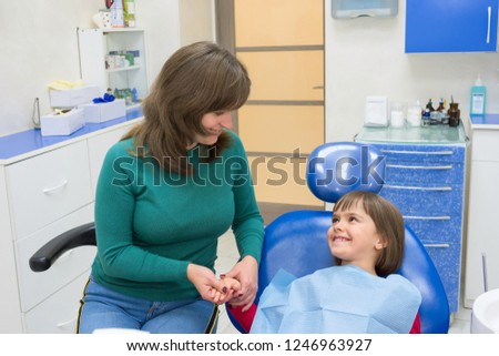 A mother with a daughter in a dentist’s office. Medicine, dentistry and health care.