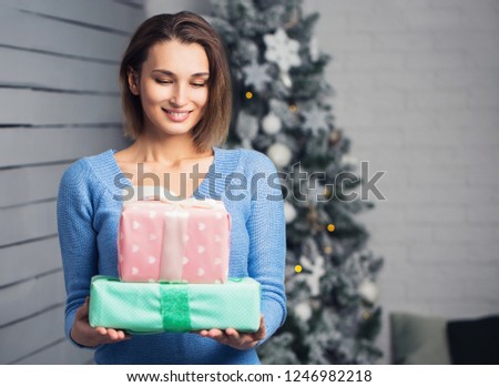 Smiling young woman with christmas present boxes