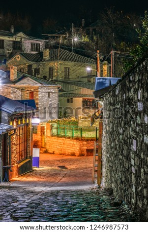 A paved path in a traditional Nimfeo village in Macedonia in Greece. The enlightened shops and lighted streets are visible. HDR