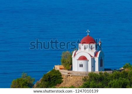 Amazing crete white church with red roof on sea background 