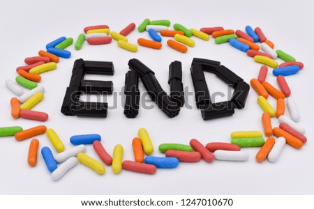 WORD END MADE WITH VARIETY OF COLORFUL CANDIES ON A WHITE BACKGROUND PLENTY OF COLORFUL SUGARY SWEETS WITH SHAPE OF BEAN THAT SHOWS HAPPINESS