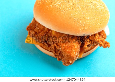 Delicious hamburger or burger with ketchup and mustard on bright blue background. Junk and fast food. Copy space
