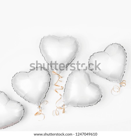 Air Balloons of heart shaped foil  on white background. Love concept. Holiday celebration. Valentine's Day or wedding/bachelorette party decoration. Metallic balloon