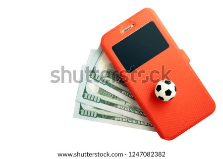 A football ball and a mobile phone in a red case lie on three hundred US dollars on a white background. Sports betting concept with a smartphone. Isolate.