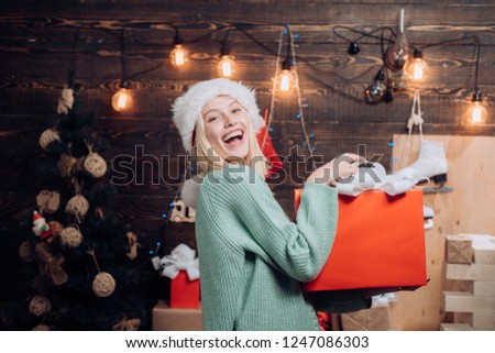 Christmas woman. Celebration. Funny. Portrait of a young smiling woman. New years eve girl. Cute young woman with santa hat. Comic grimace. Home Holiday