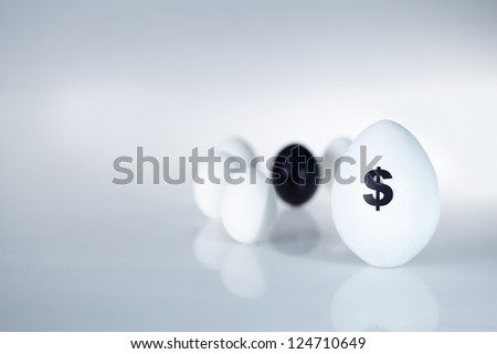 Image of big white egg with dollar sign on background of small eggs