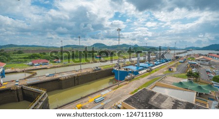 Large cargo ships pass through the Panama Canal locks.  This everyday event, provides income from both fees, and tourism, for the whole country.